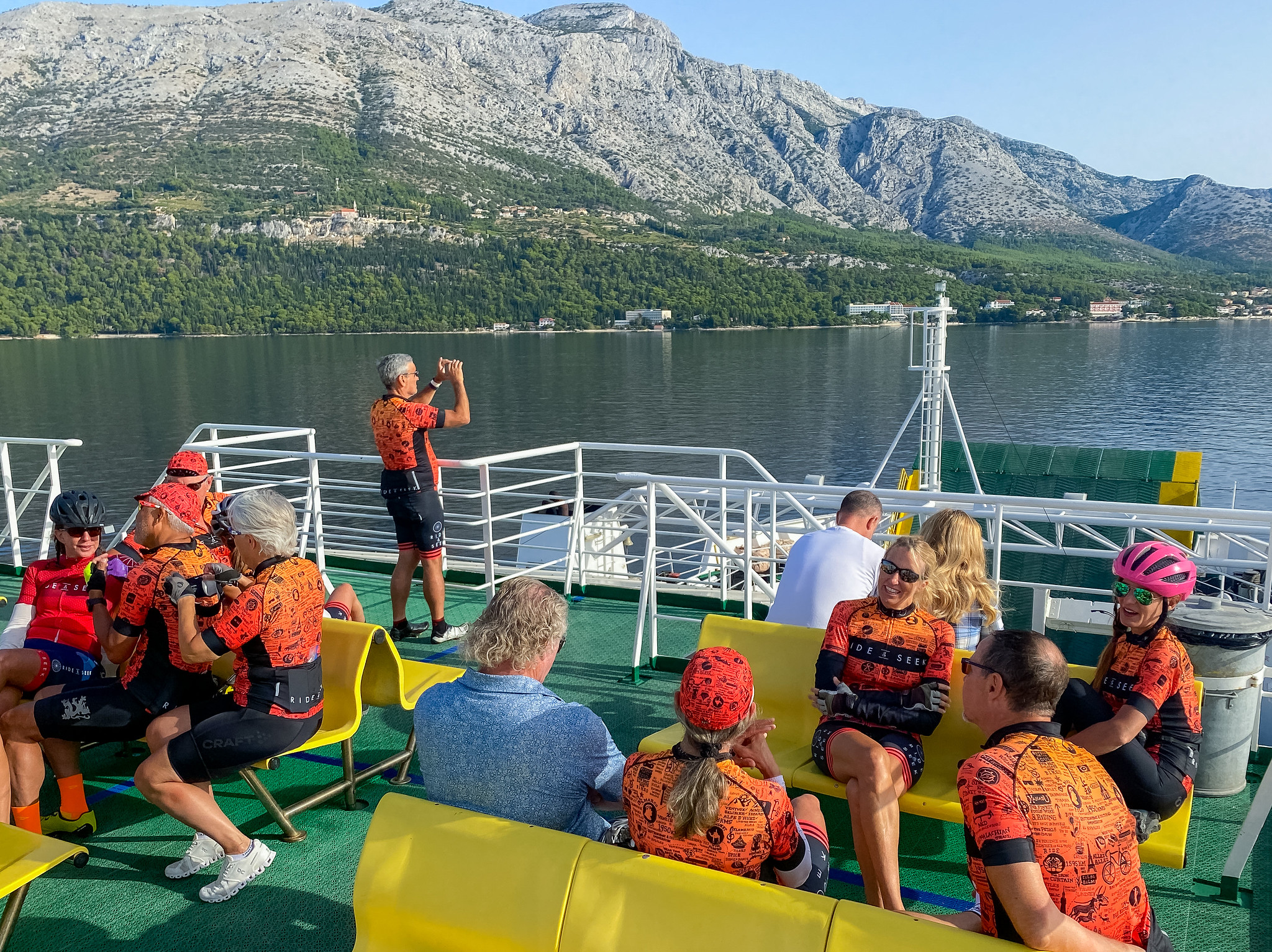 Ride and Seekers onboard a ferry with views of cliffs across the water